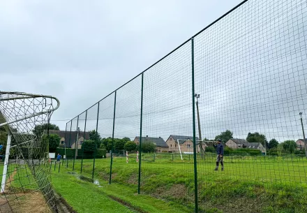 Remplacement du filet pare-ballon sur un terrain de football